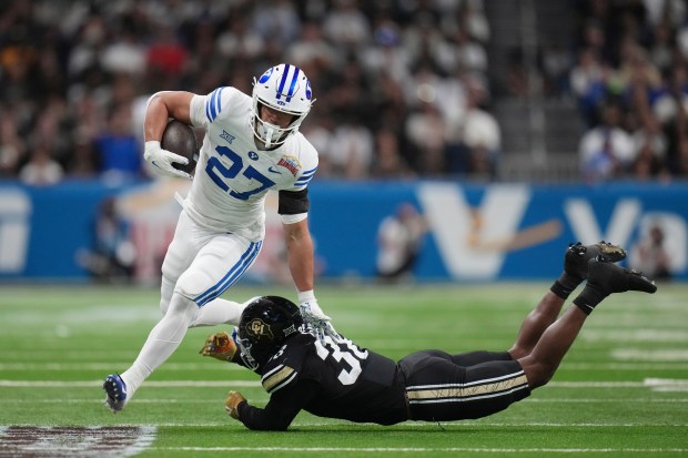 BYU running back LJ Martin (27) runs past Colorado linebacker Brendan Gant (38) during the first half of the Alamo Bowl NCAA college football game, Saturday, Dec. 28, 2024, in San Antonio. (AP Photo/Eric Gay)