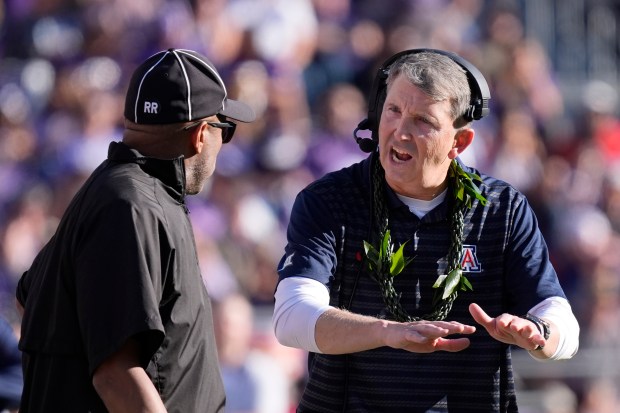Arizona head coach Brent Brennan, right, makes a point with an official during the first half of an NCAA college football game against TCU, Saturday, Nov. 23, 2024, in Fort Worth, Texas. (AP Photo/LM Otero)
