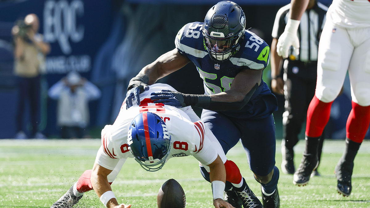 New York Giants quarterback Daniel Jones (8) fumbles while under pursuit from Seattle Seahawks linebacker Derick Hall (58) during the first quarter at Lumen Field. New York recovered the fumble.