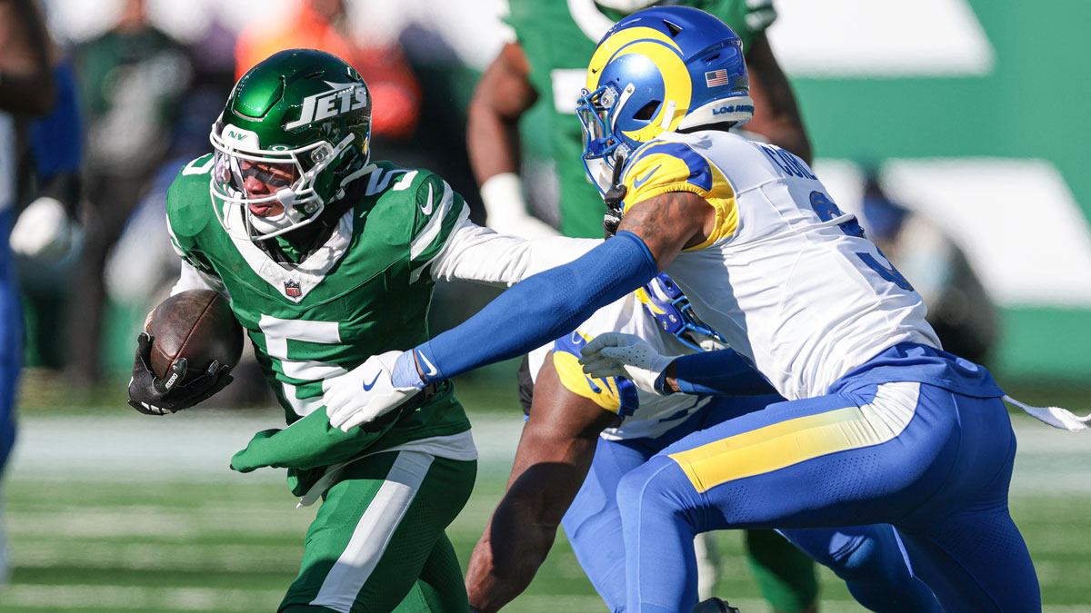 Dec 22, 2024; East Rutherford, New Jersey, USA; New York Jets wide receiver Garrett Wilson (5) gains yards after catch as Los Angeles Rams safety Kamren Curl (3) pursues during the first half at MetLife Stadium.