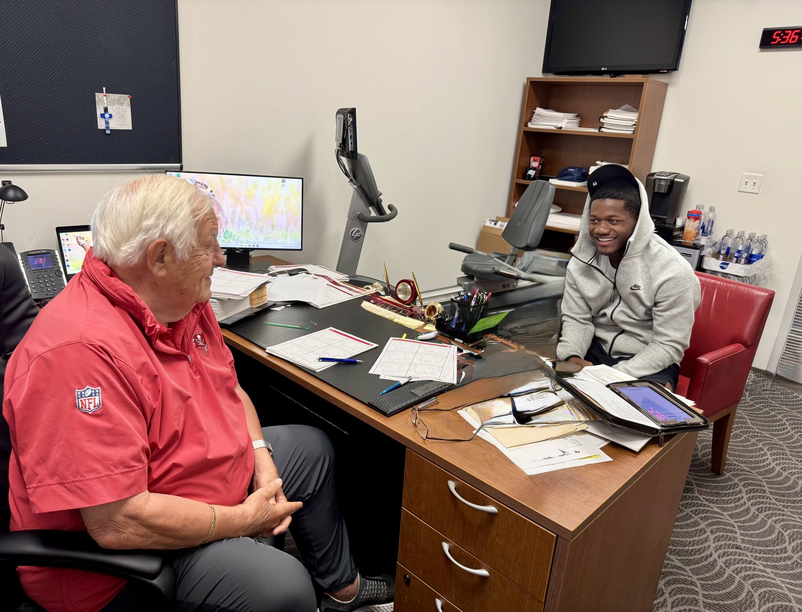 Bucs offensive coach Tom Moore and running back Bucky Irving meet in Moore's office in the early morning.