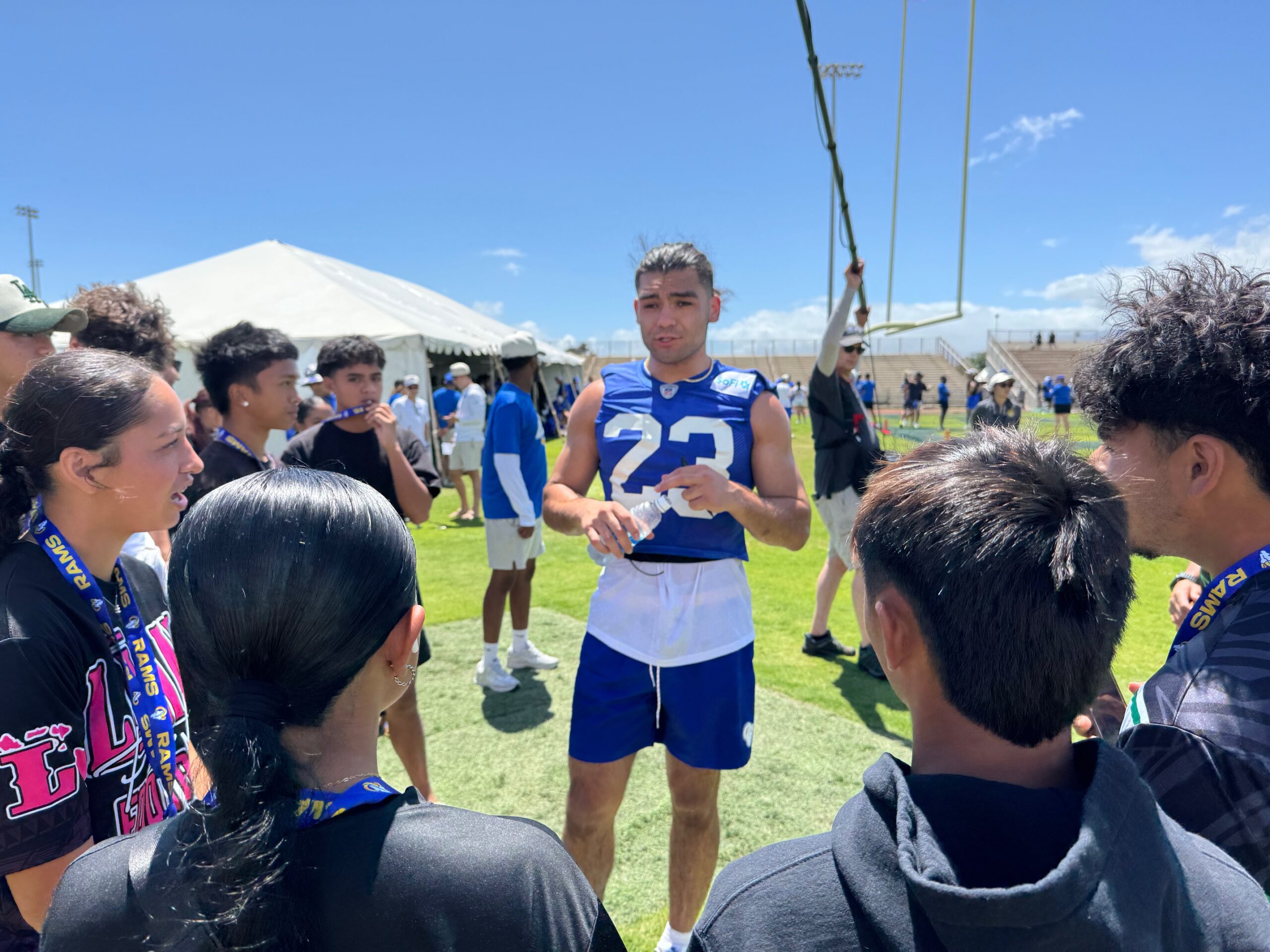 Los Angeles Rams wide receiver Puka Nacua speaks with players from Lanai High School girls and boys football teams on Tuesday at War Memorial Stadium. HJI / ROB COLLIAS photo