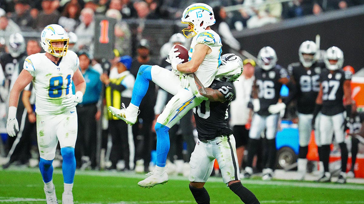 Los Angeles Chargers wide receiver Ladd McConkey (15) makes a catch while being tackled by Las Vegas Raiders safety Isaiah Pola-Mao (20) during the second quarter at Allegiant Stadium.