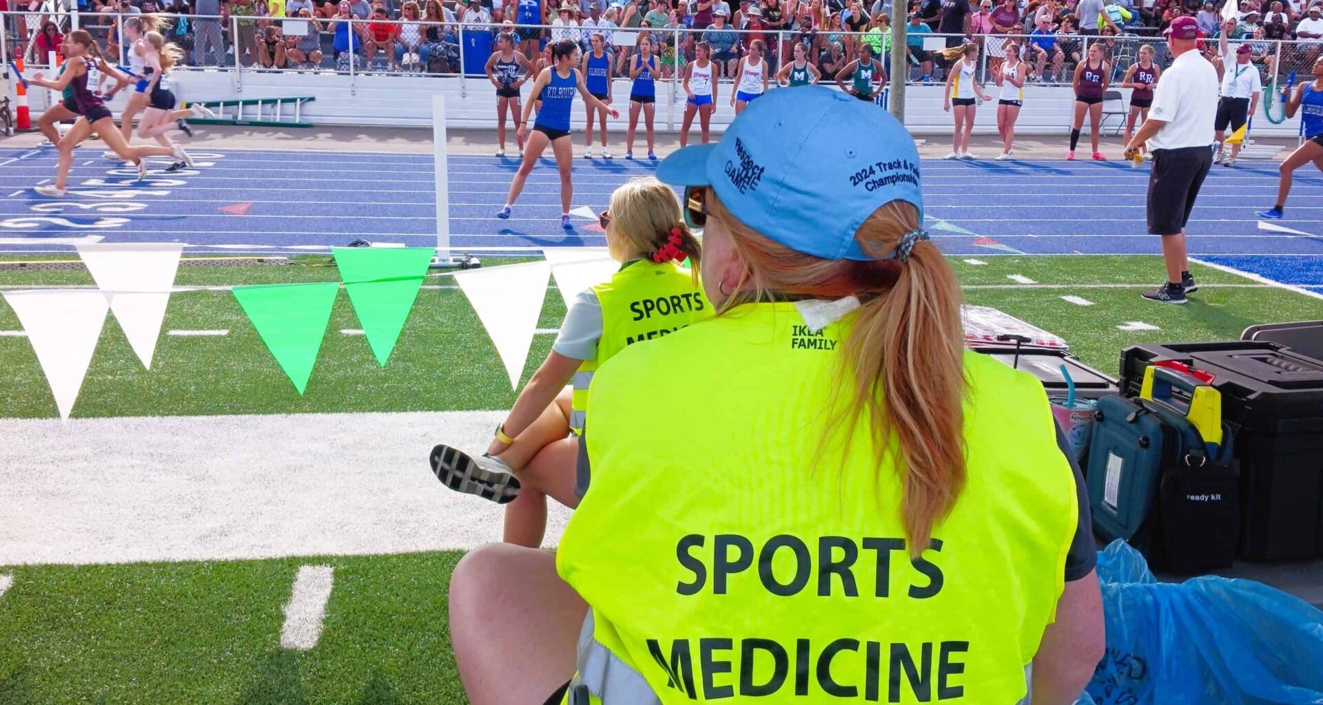 Sports medicine provider sitting on sidelines