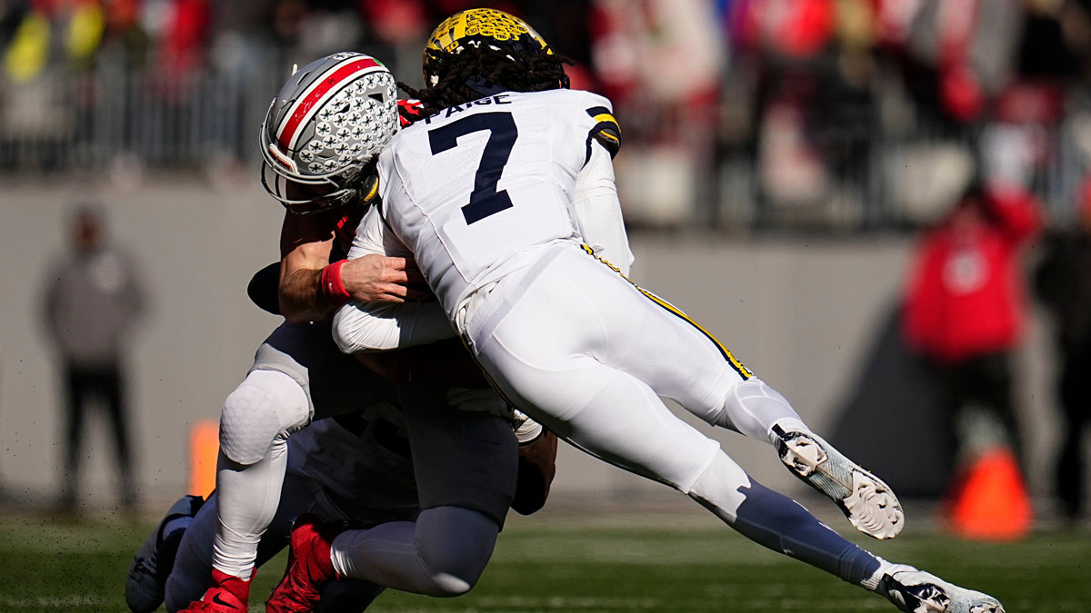 Ohio State Buckeyes quarterback Will Howard (18) is hit by Michigan Wolverines defensive back Makari Paige (7) during the first half of the NCAA football game at Ohio Stadium in Columbus on Saturday, Nov. 30, 2024. Howard left the game briefly after the play.