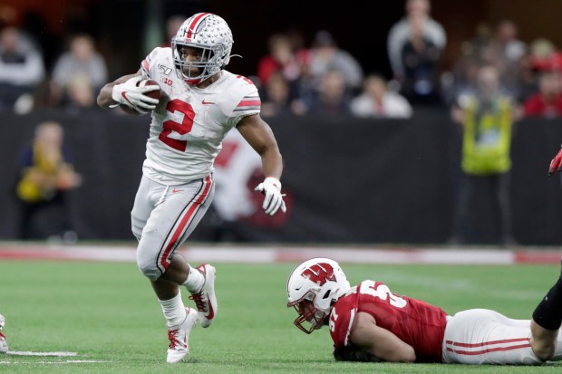 Ohio State running back J.K. Dobbins (2) runs past Wisconsin linebacker Jack Sanborn during the second half of the Big Ten championship NCAA college football game Saturday, Dec. 7, 2019, in Indianapolis. (AP Photo/Michael Conroy)
