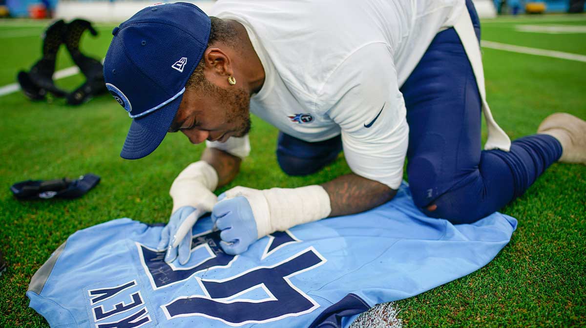 Tennessee Titans linebacker Arden Key (49) autographs his jersey to swap with a Jacksonville Jaguars player after the game at Nissan Stadium in Nashville, Tenn., Sunday, Dec. 8, 2024.