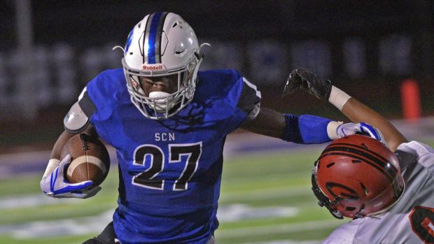 St. Charles North's Tyler Nubin, left, sheds a tackle against Glenbard East on Friday, Sept. 22, 2017.