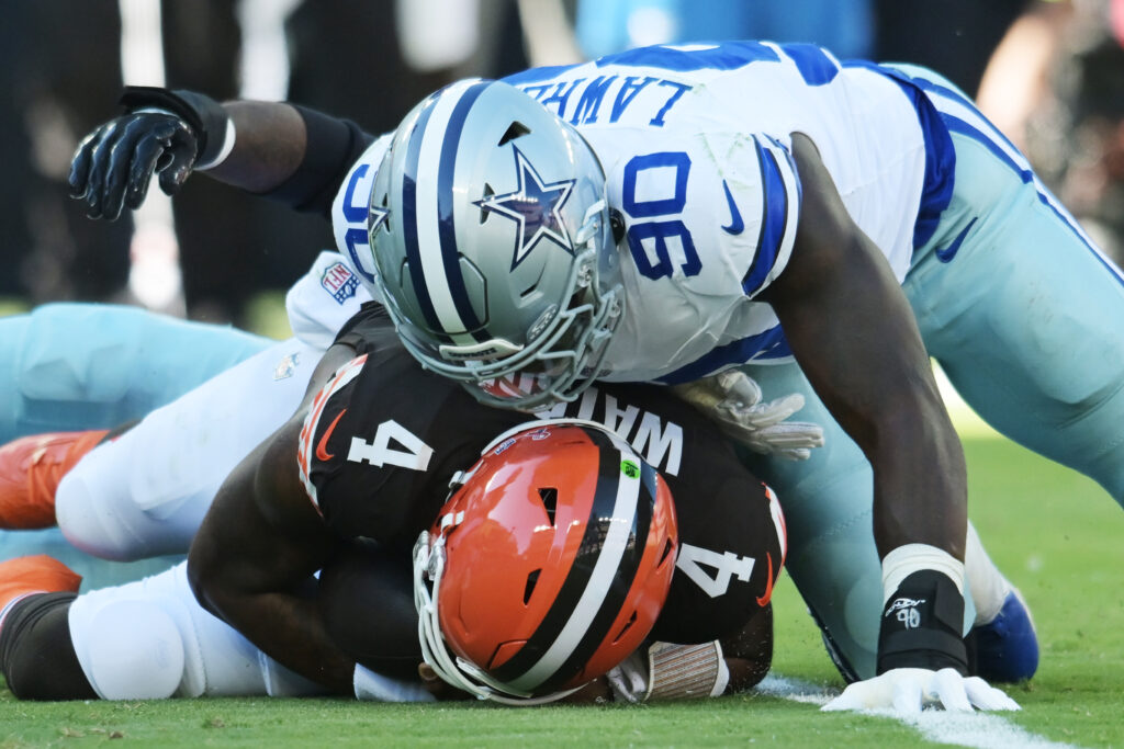 Dallas Cowboys defensive end DeMarcus Lawrence (90) lies on Cleveland Browns quarterback Deshaun Watson (4) after a sack.