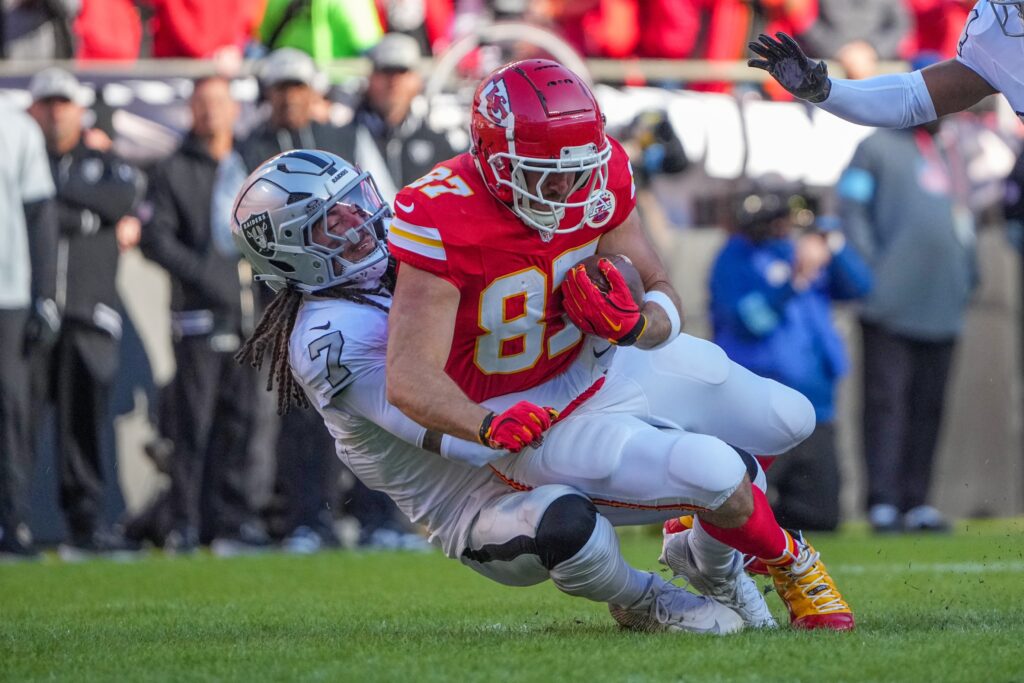 Kansas City Chiefs tight end Travis Kelce (87) runs the ball as Las Vegas Raiders safety Tre'von Moehrig (7) makes the tackle during the first half at GEHA Field.