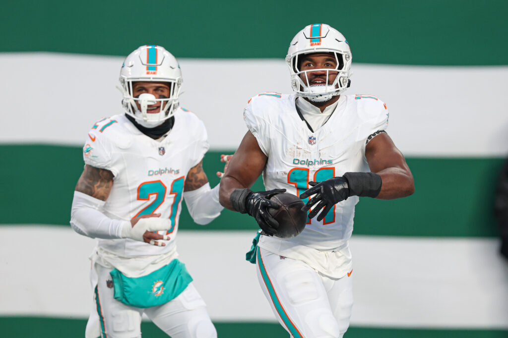 Miami Dolphins linebacker Tyrel Dodson (11) celebrates his interception with safety Jordan Poyer (21) during the first quarter against the New York Jets at MetLife Stadium.