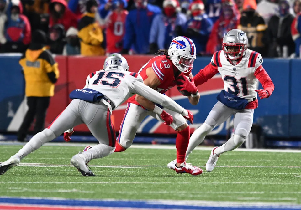 Buffalo Bills wide receiver Mack Hollins (13) runs between New England Patriots cornerback Jonathan Jones (31) and safety Marte Mapu (15) in the second quarter at Highmark Stadium.Mark Konezny-Imagn Images