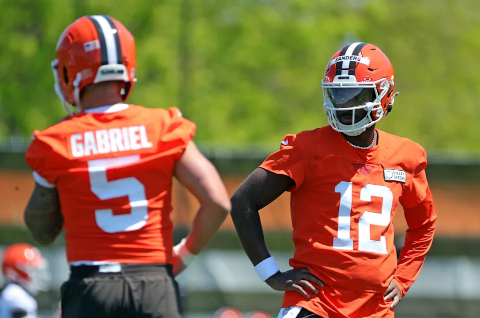Cleveland Browns quarterback Shedeur Sanders (12) watches quarterback Dillon Gabriel (5) during day two of NFL rookie minicamp at the Cleveland Browns training facility on Saturday, May 10, 2025, in Berea, Ohio.