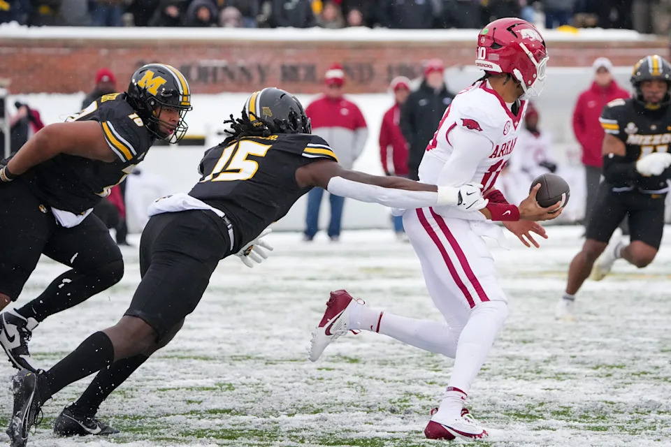 Nov 30, 2024; Columbia, Missouri, USA; Arkansas Razorbacks quarterback Taylen Green (10) is sacked by Missouri Tigers defensive end Johnny Walker Jr. (15) during the first half at Faurot Field at Memorial Stadium. Mandatory Credit: Denny Medley-Imagn Images