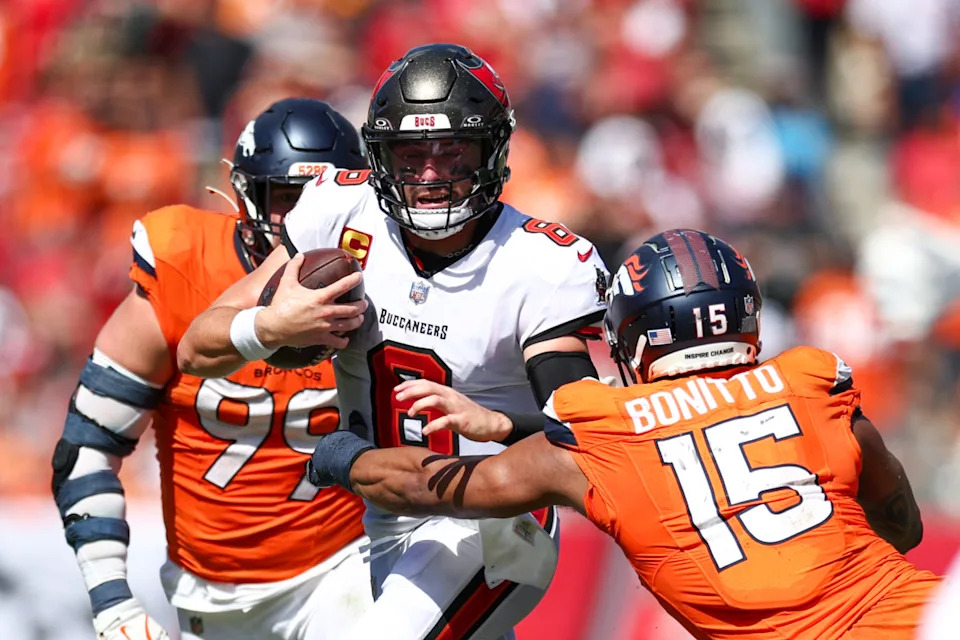 Tampa Bay Buccaneers quarterback Baker Mayfield (6) tries to avoid a tackle by Denver Broncos linebacker Nik Bonitto (15).Nathan Ray Seebeck-Imagn Images