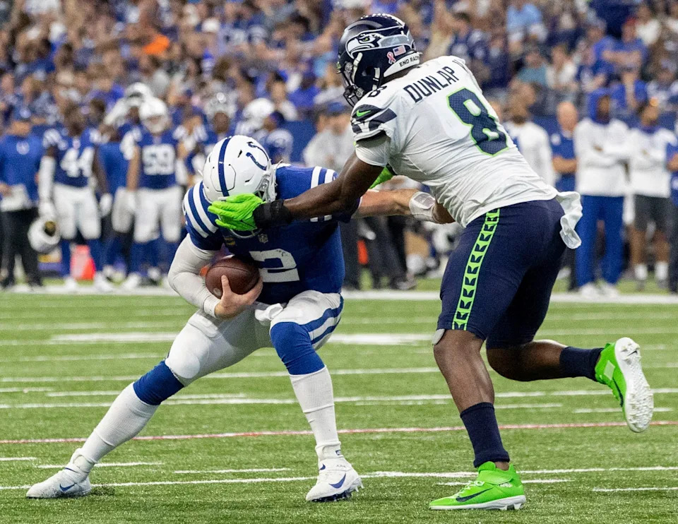 Indianapolis Colts quarterback Carson Wentz (2) is wrapped up by Seattle Seahawks defensive end Carlos Dunlap (8) while going for a two-point conversion late in the fourth quarter Sunday, Sept. 12, 2021, during the regular season opener at Lucas Oil Stadium in Indianapolis.