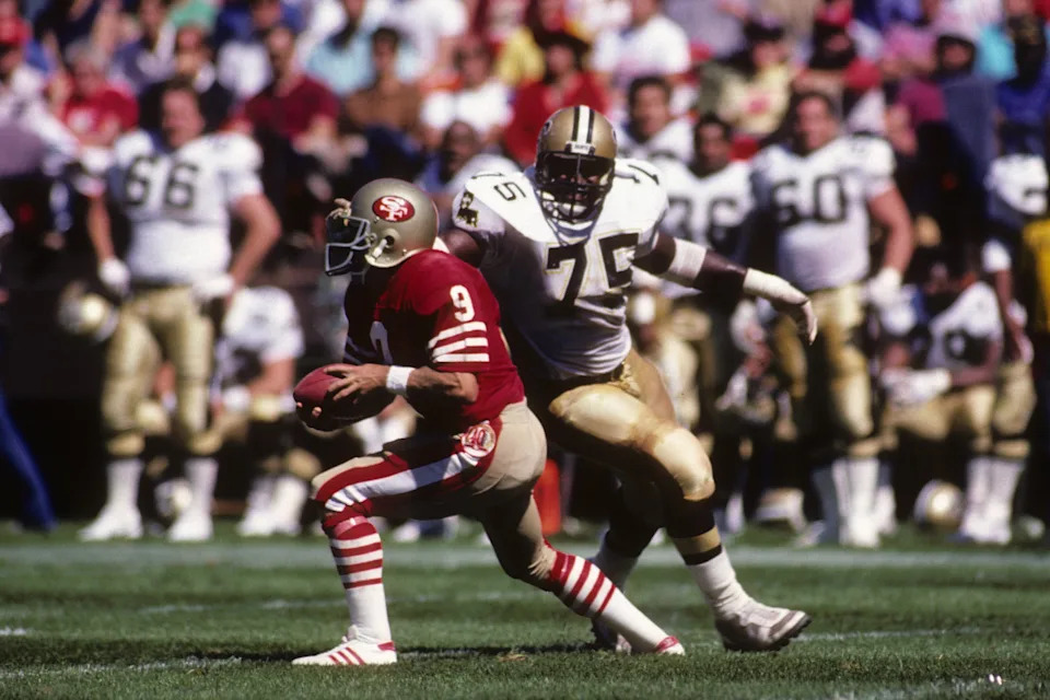 SAN FRANCISCO - SEPTEMBER 21: Defensive tackle Bruce Clark #75 of the New Orleans Saints closes in quarterback Jeff Kemp #9 of the San Francisco 49ers during the game at Candlestick Park on September 21, 1986 in San Francisco, California. The 49ers won 26-17. (Photo by George Rose/Getty Images)