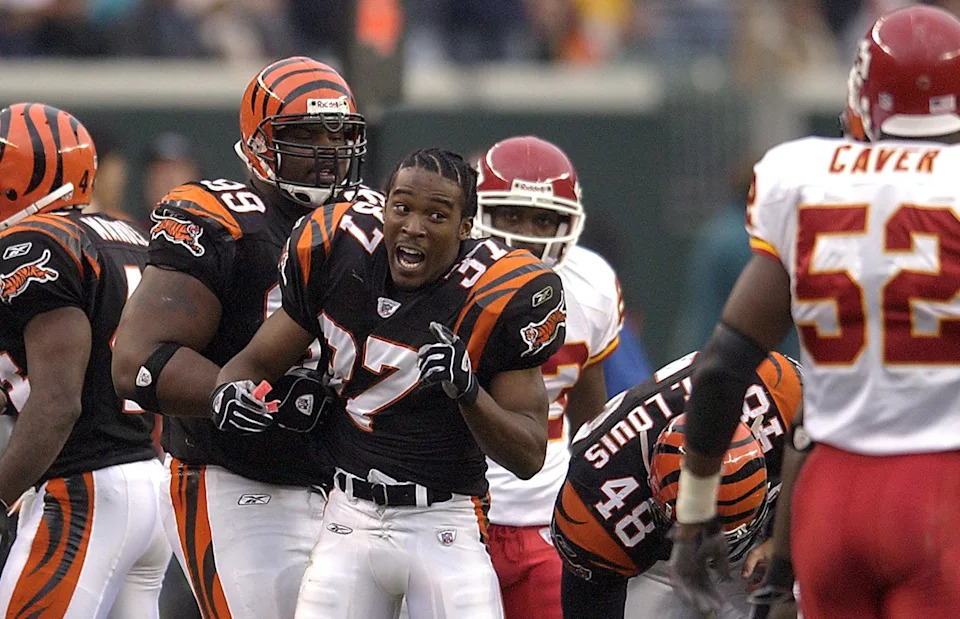 Former Bengals defensive tackle Oliver Gibson (99) restrains teammate Reggie Myles against Kansas City