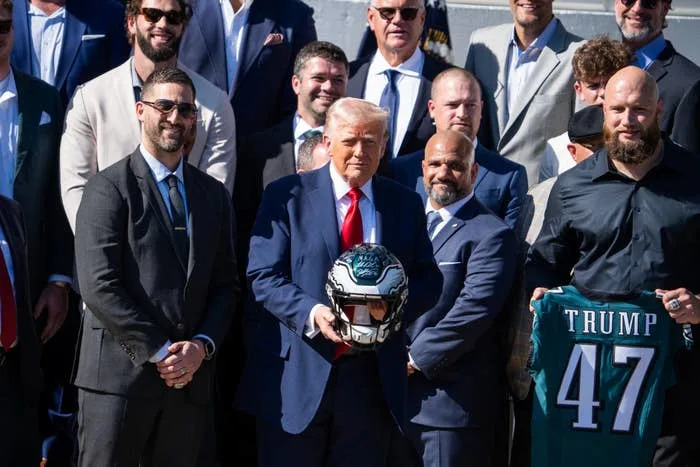 Trump posing with offensive tackle Lane Johnson and head coach Nick Sirianni during a ceremony with the Eagles