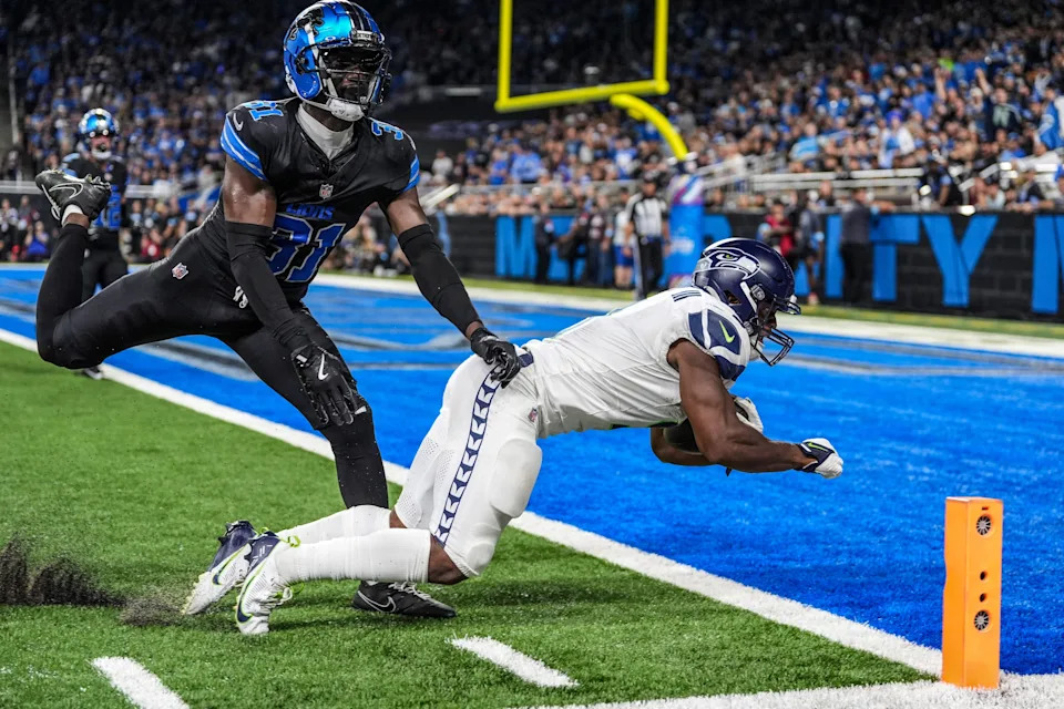 Seattle Seahawks running back Kenneth Walker III (9) scores a touchdown against the Detroit Lions safety Kerby Joseph (31) at Ford Field in Detroit, Tuesday, Oct. 1, 2024.