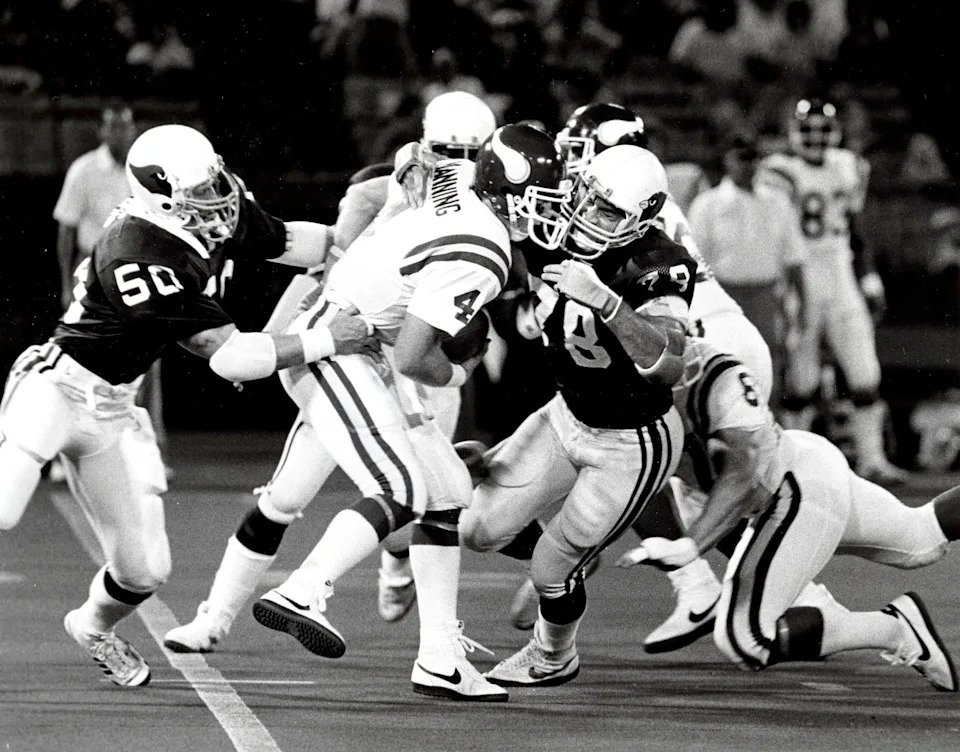 Aug 24, 1984; St. Louis, MO, USA; FILE PHOTO; Minnesota Vikings quarterback Archie Manning (4) is sacked by St. Louis Cardinals defensive tackle Elois Grooms (78) and Bob Harris (50) during a pre-season game at Busch Stadium. Mandatory Credit: Herb Weitman-USA TODAY Sports