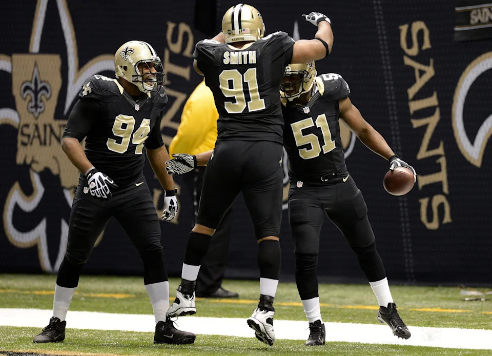 Dec 30, 2012; New Orleans, LA, USA; New Orleans Saints outside linebacker Jonathan Vilma (51) celebrates with teammates defensive end Will Smith (91) and New defensive end Cameron Jordan (94) after scoring a touchdown on an interception off Carolina Panthers quarterback Cam Newton (not pictured) during second quarter of their game at the Mercedes-Benz Superdome. John David Mercer-USA TODAY Sports