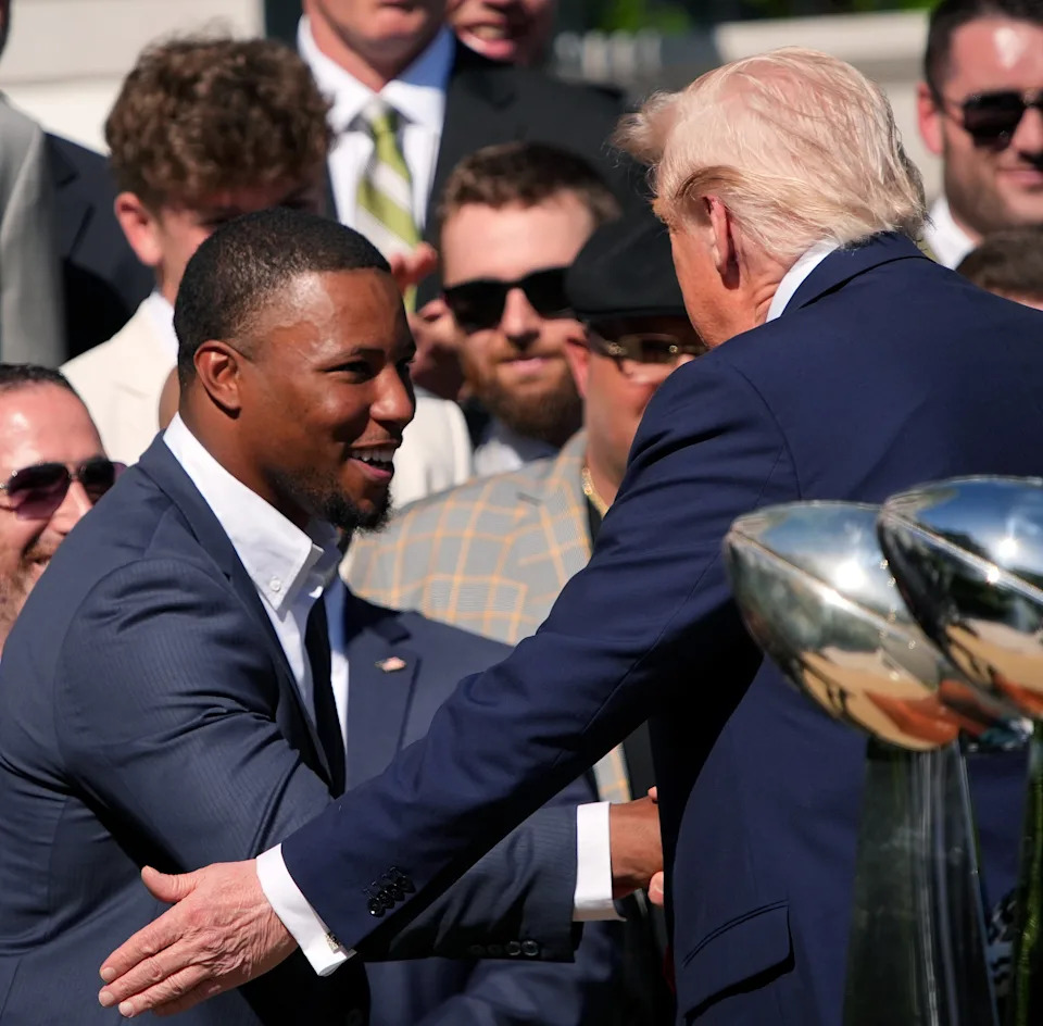 Saquon Barkley shaking hands with Trump at a group event
