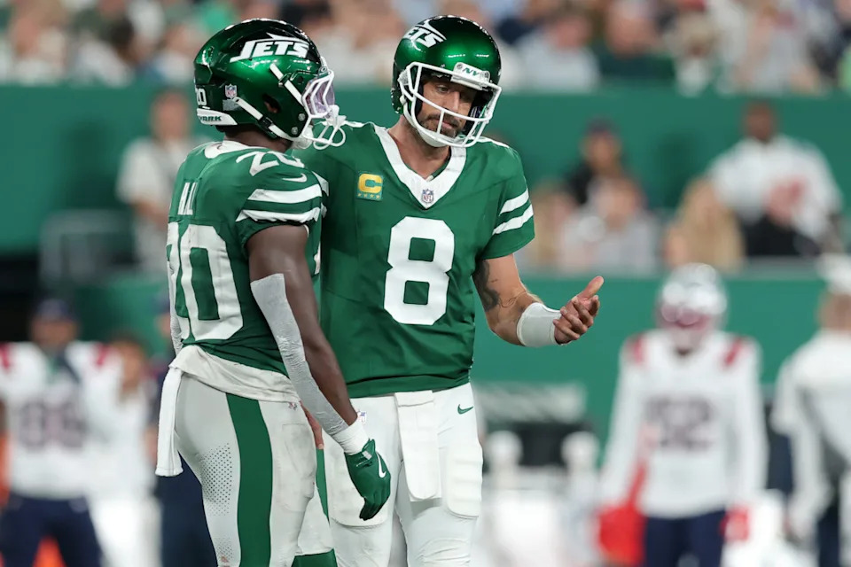 New York Jets quarterback Aaron Rodgers (8) reacts as he talks to running back Breece Hall (20).Brad Penner-Imagn Images