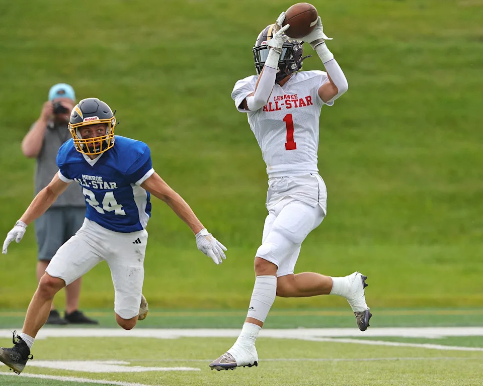 Talan Hutchinson of Onsted makes a catch in front of Monroe's Donovan Howard during the Monroe County vs. Lenawee County All-Star Football Game at Adrian College on Friday, June 20, 2025.