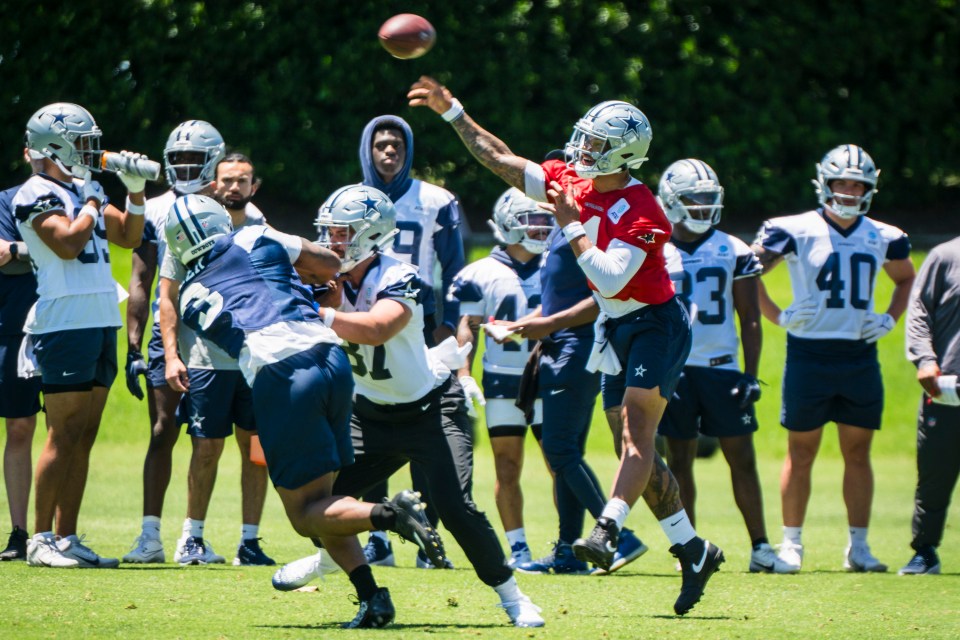 Dak Prescott throwing a football during Dallas Cowboys practice.