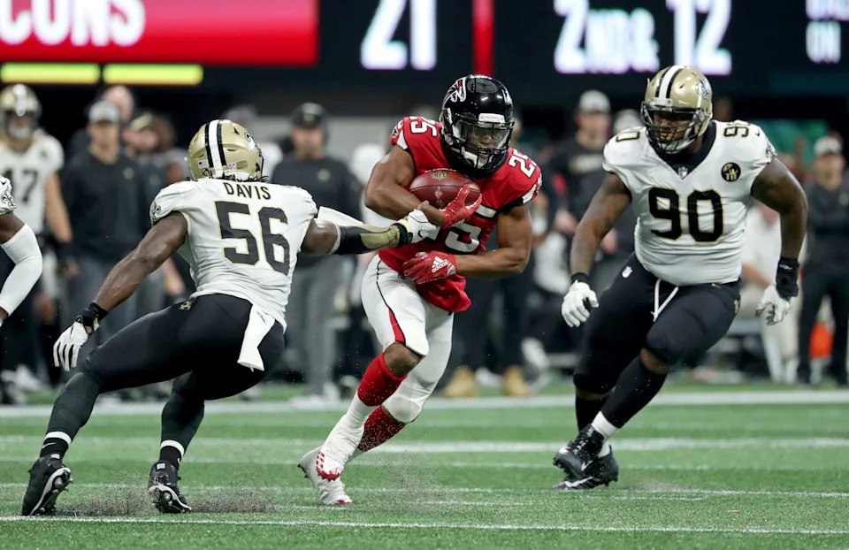 Sep 23, 2018; Atlanta, GA, USA; Atlanta Falcons running back Ito Smith (25) makes a move against New Orleans Saints linebacker Demario Davis (56) and defensive tackle Jay Bromley (90) in the third quarter at Mercedes-Benz Stadium. Mandatory Credit: Jason Getz-USA TODAY Sports