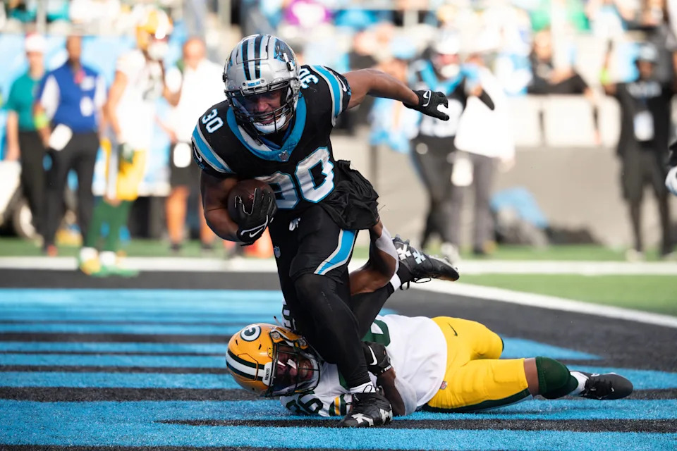 Dec 24, 2023; Charlotte, North Carolina, USA; Carolina Panthers running back Chuba Hubbard (30) scores a touchdown as Green Bay Packers safety Darnell Savage (26) defends in the third quarter at Bank of America Stadium. Mandatory Credit: Bob Donnan-USA TODAY Sports