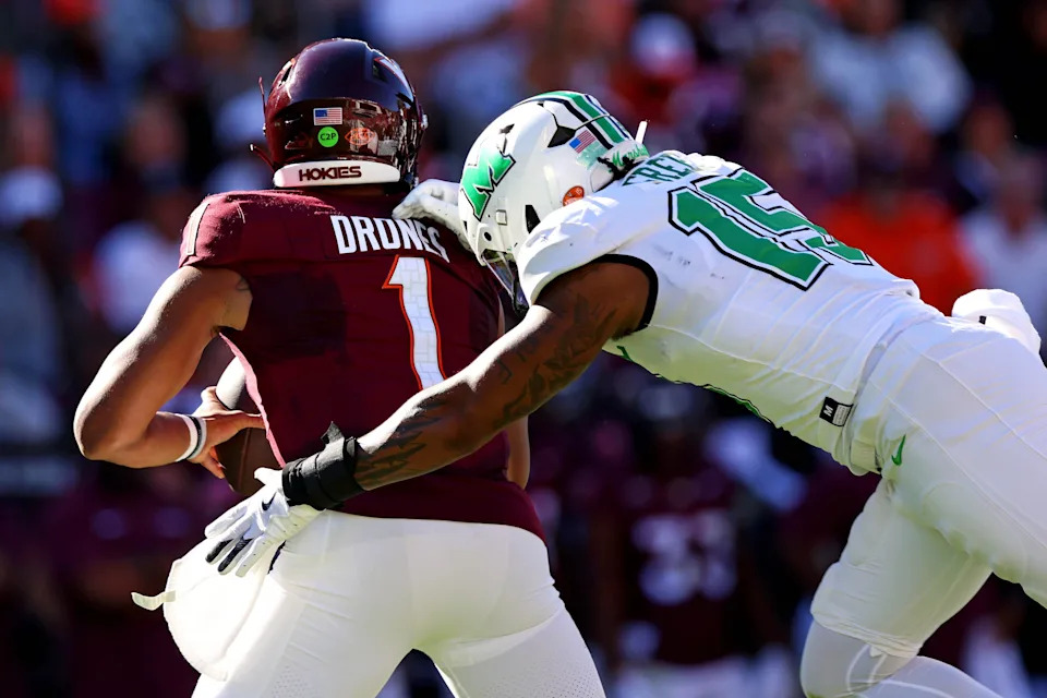 Sep 7, 2024; Blacksburg, Virginia, USA; Marshall Thundering Herd defensive lineman Mike Green (15) sacks Virginia Tech Hokies quarterback Kyron Drones (1) during the first quarter at Lane Stadium. Mandatory Credit: Peter Casey-Imagn Images