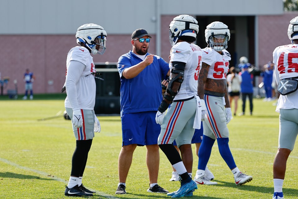 New York Giants outside linebackers coach Drew Wilkins with players Kayvon Thibodeaux and Azeez Ojulari at training camp.