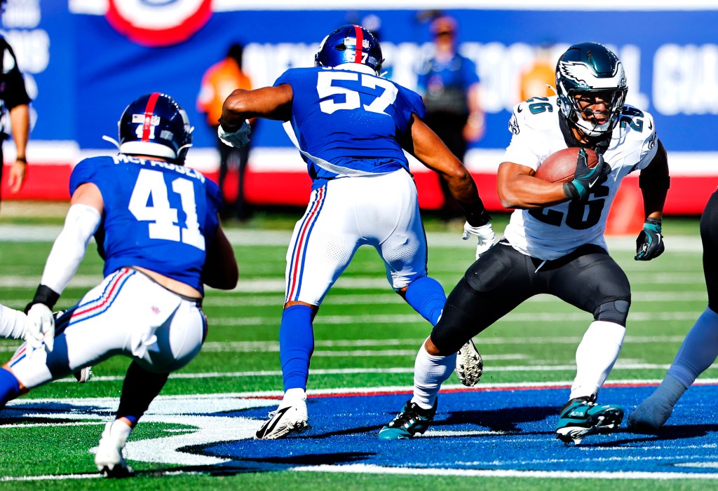 Philadelphia Eagles running back Saquon Barkley rushes past New York Giants linebackers.