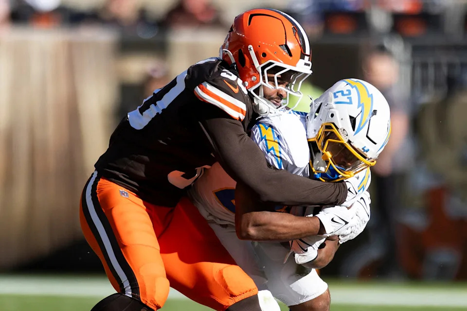 Nov 3, 2024; Cleveland, Ohio, USA; Los Angeles Chargers running back J.K. Dobbins (27) runs the ball as Cleveland Browns linebacker Devin Bush (30) tackles him during the second quarter at Huntington Bank Field. Mandatory Credit: Scott Galvin-Imagn Images