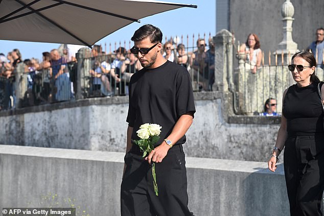 Dias wore all black as he carried a bouquet of flowers inside the church ahead of the ceremony