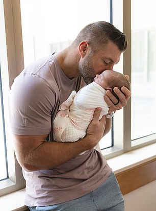 The college football icon held his new daughter close in one of the photos