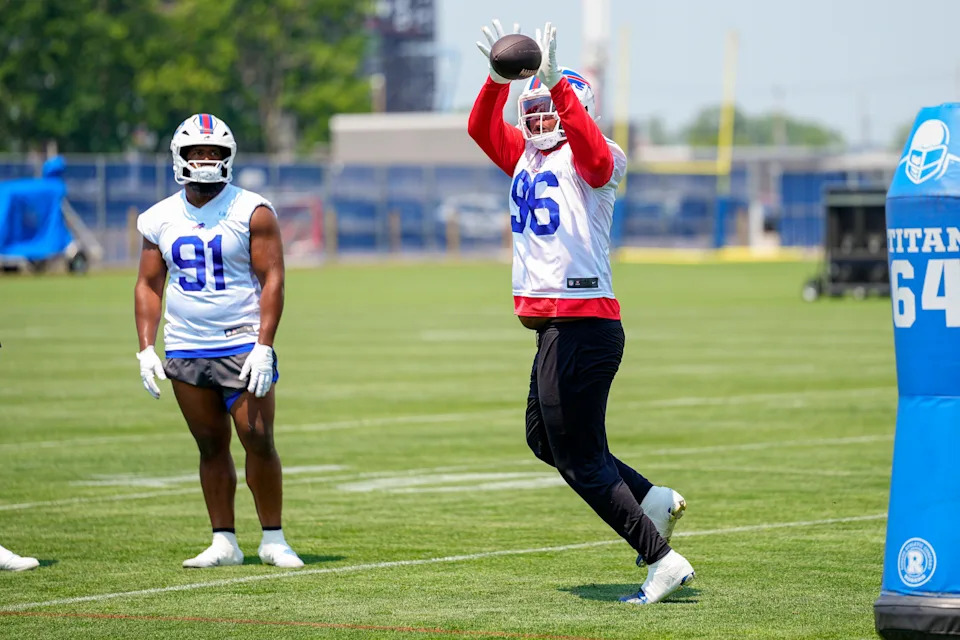 Jun 11, 2025; Orchard Park, NY, USA; Buffalo Bills defensive tackle Deone Walker (96) makes a catch with defensive tackle Ed Oliver (91) looking on during Minicamp at Highmark Stadium. Mandatory Credit: Gregory Fisher-Imagn Images