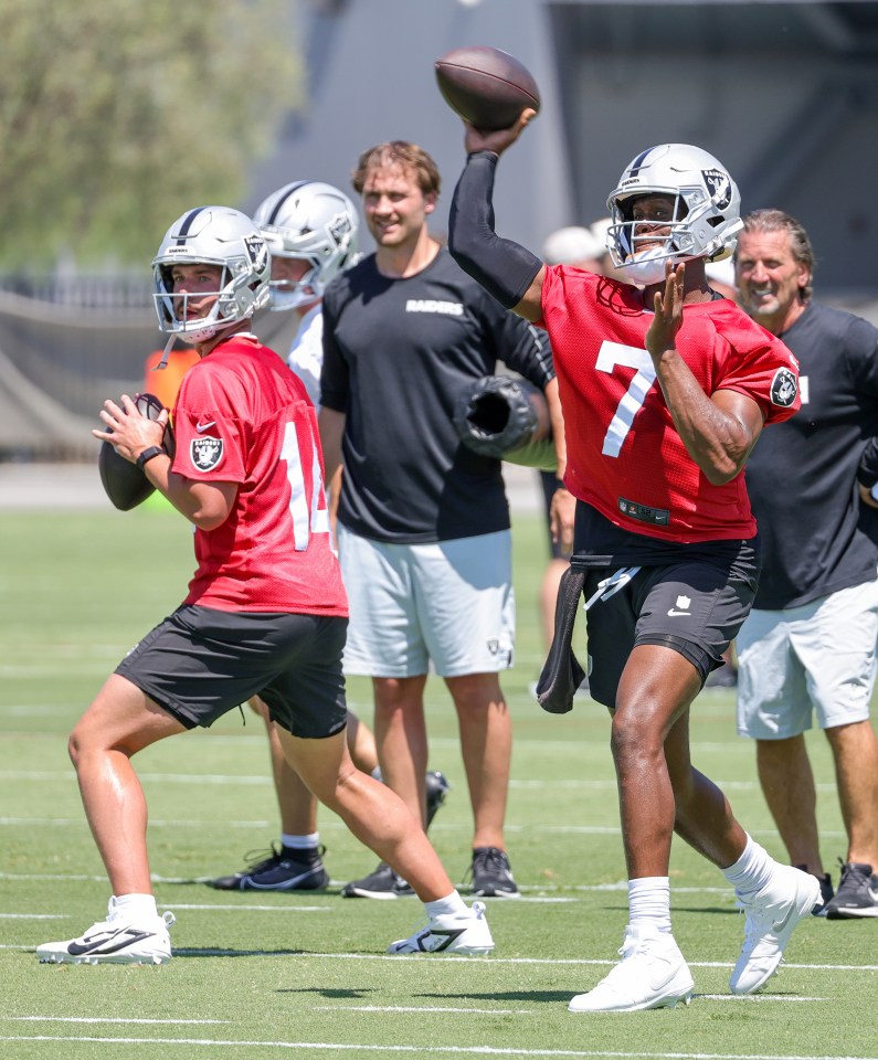 Geno Smith #7 and Carter Bradley #14 of the Las Vegas Raiders throwing footballs at practice.