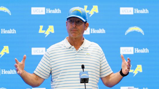 Jim Harbaugh of the Los Angeles Chargers talks with members of the media before mandatory minicamp at The Bolt on June 12, 2025 in El Segundo, California. 