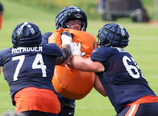 Chicago Bears center Drew Dalman (52), center, gets double teamed by Jordan McFadden (74) and Luke Newman (65), right, during training camp on July 28, 2025, in Lake Forest. (Stacey Wescott/Chicago Tribune)