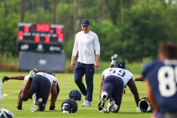 Chicago Bears head coach Ben Johnson watches as players stretch at training camp on July 28, 2025, in Lake Forest. (Stacey Wescott/Chicago Tribune)