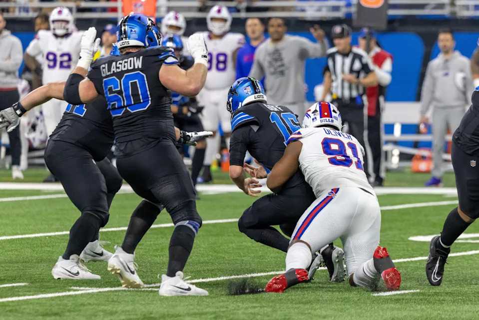 Dec 15, 2024; Detroit, Michigan, USA; Detroit Lions quarterback Jared Goff (16) is sacked by Buffalo Bills defensive tackle Ed Oliver (91) during the first quarter at Ford Field. Mandatory Credit: David Reginek-Imagn Images