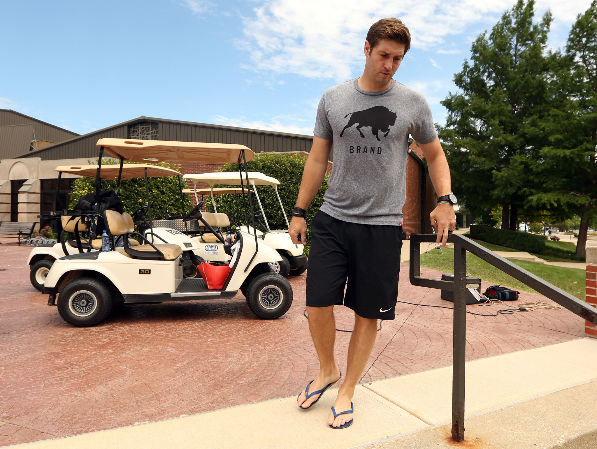 Jay Cutler imakes his way to a media huddle as Bears players report in 2015.