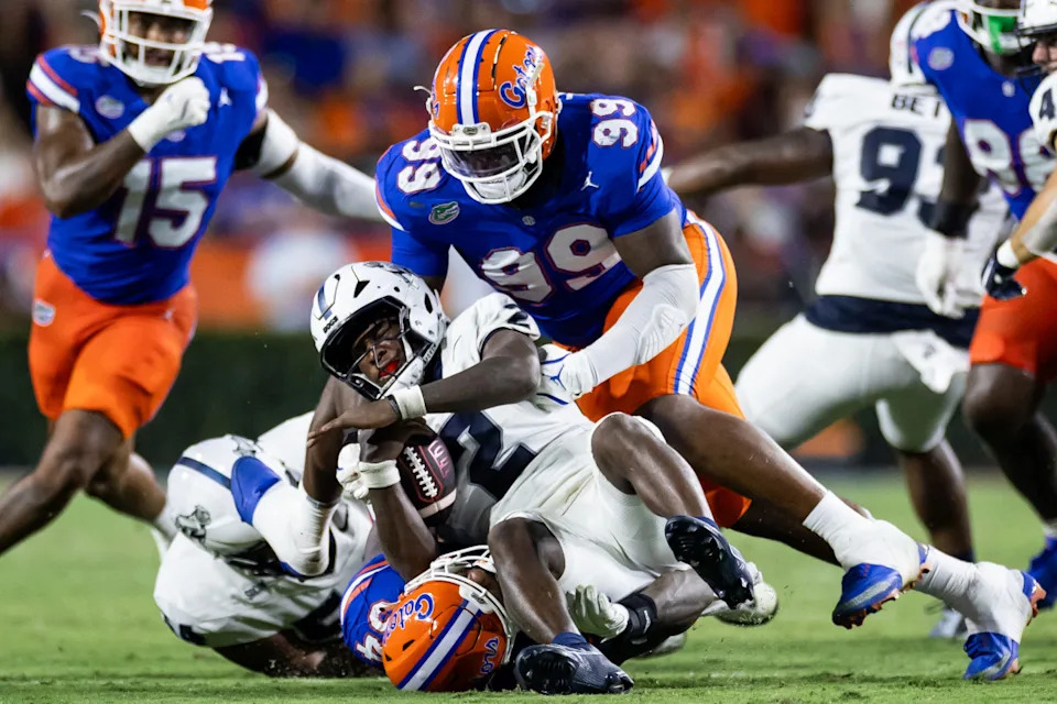 Florida Gators defensive lineman Cam Jackson (99) and Florida Gators edge George Gumbs Jr. (34) tackle Samford Bulldogs quarterback Quincy Crittendon (2) during the first half at Ben Hill Griffin Stadium.© Matt Pendleton-Imagn Images
