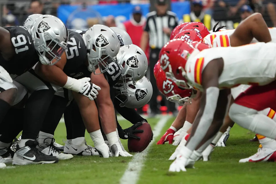 Oct 27, 2024; Paradise, Nevada, USA; Helmets at the line of scrimmage as Las Vegas Raiders long snapper Jacob Bobenmoyer (50) snaps the ball against the Kansas City Chiefs in the first half at Allegiant Stadium. Mandatory Credit: Kirby Lee-Imagn Images
