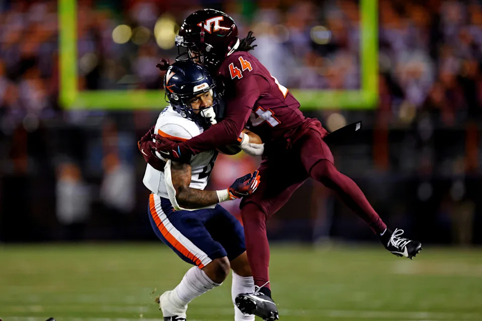 Nov 30, 2024; Blacksburg, Virginia, USA; Virginia Tech Hokies cornerback Dorian Strong (44) tackles Virginia Cavaliers wide receiver Chris Tyree (4) during the fourth quarter at Lane Stadium. Mandatory Credit: Peter Casey-Imagn Images