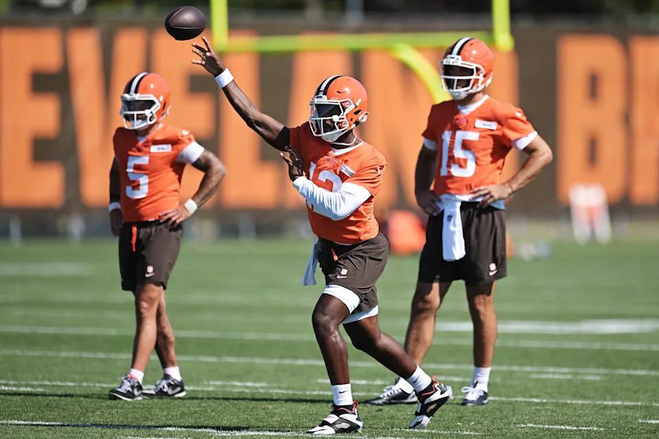 Cleveland Browns quarterback Shedeur Sanders throws a pass as Joe Flacco (15) and Dillon Gabriel (5) look on during training camp Wednesday.