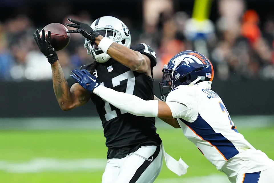 Jan 7, 2024; Paradise, Nevada, USA; Las Vegas Raiders wide receiver Davante Adams (17) makes a catch against Denver Broncos cornerback Pat Surtain II (2) during the second quarter at Allegiant Stadium. Mandatory Credit: Stephen R. Sylvanie-USA TODAY Sports
